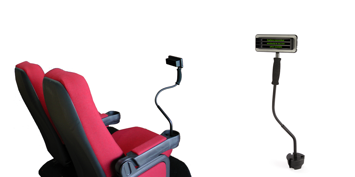 Cinema seats beside a cup-holder mounted closed caption display on a flexible arm
